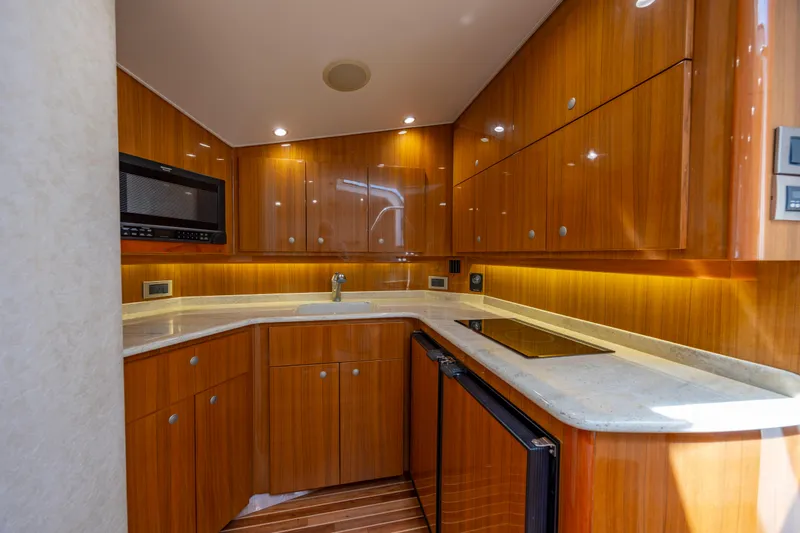 Life Is Good Yacht Photos Pics Luxurious wooden kitchen interior of 2013 Viking 42 yacht, featuring modern appliances and sleek countertops.