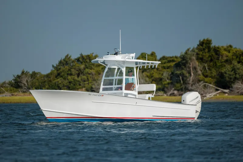  Yacht Photos Pics 2019 Gamefisherman 26 Cuddy Cabin boat cruising on water near shoreline.