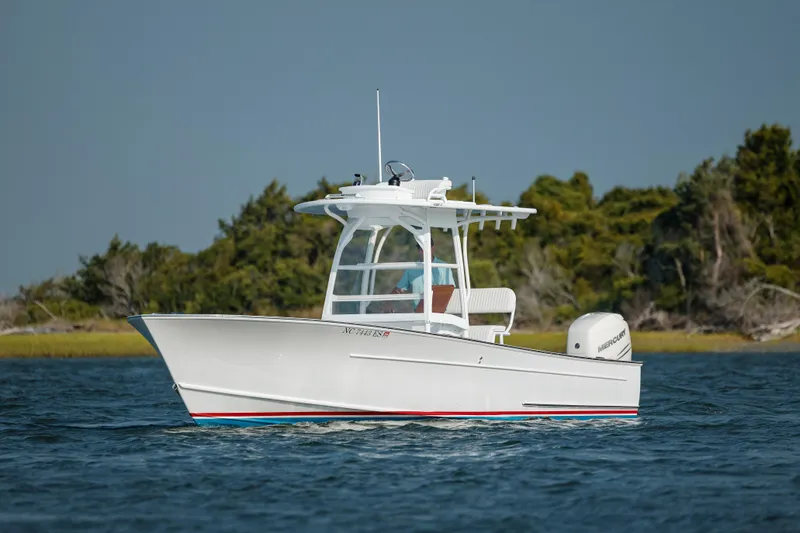  Yacht Photos Pics 2019 Gamefisherman 26 Cuddy Cabin boat cruising on water near shoreline.