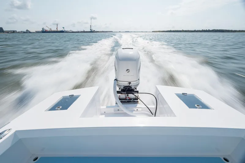  Yacht Photos Pics 2019 Gamefisherman 26 Cuddy Cabin speeding on water, rear view of outboard motor.
