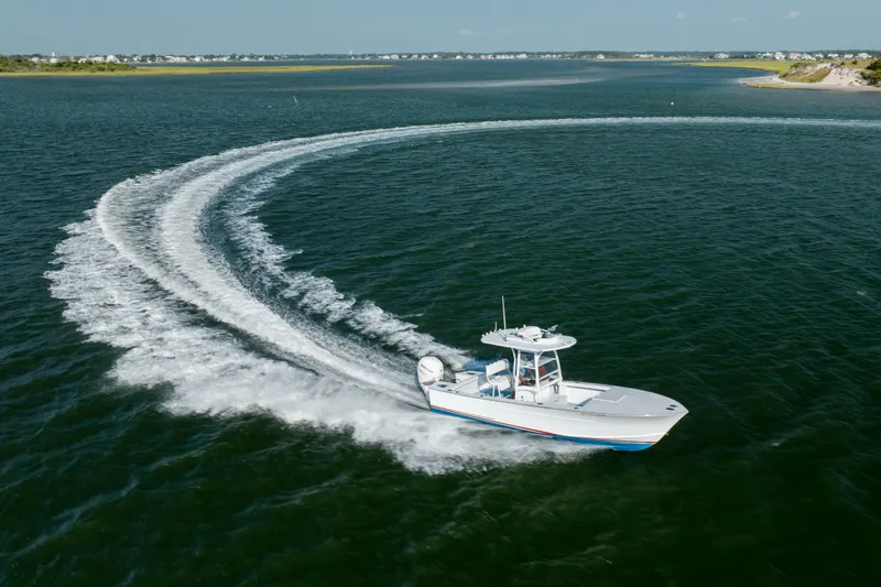  Yacht Photos Pics 2019 Gamefisherman 26 Cuddy Cabin boat making a sharp turn on open water.