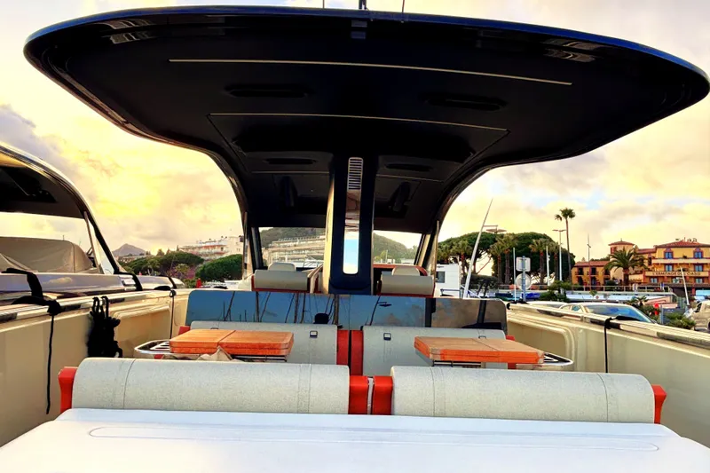  Yacht Photos Pics 2024 Invictus TT 420 yacht interior with modern seating and tables, docked at sunset.
