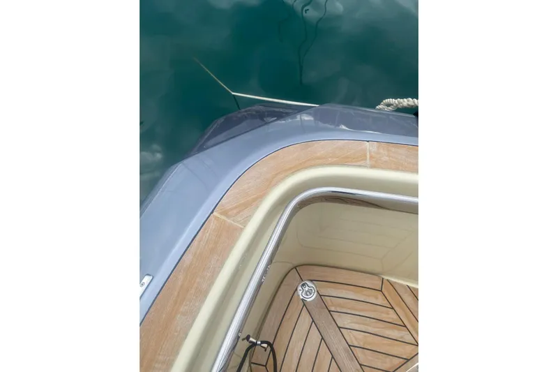  Yacht Photos Pics 2024 Invictus TT 420 yacht deck with wood finish, docked on calm water.