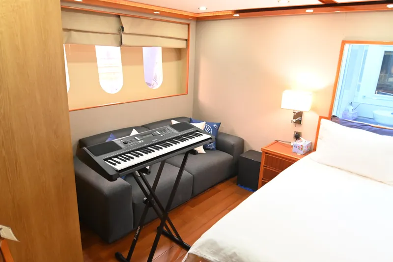  Yacht Photos Pics Cozy yacht bedroom with keyboard, sofa, and bedside lamp, Accelera 82, 2014 model.