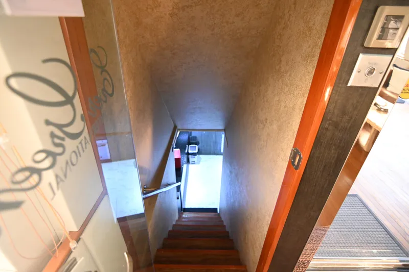  Yacht Photos Pics Narrow wooden staircase leading to a lower level in a modern interior space.