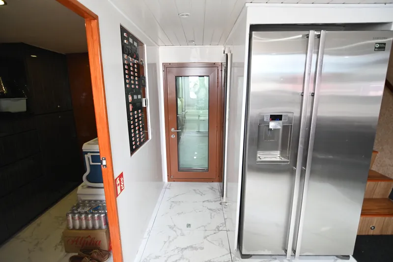  Yacht Photos Pics Modern kitchen with stainless steel refrigerator, marble floor, and wooden door in Accelera 82 yacht.