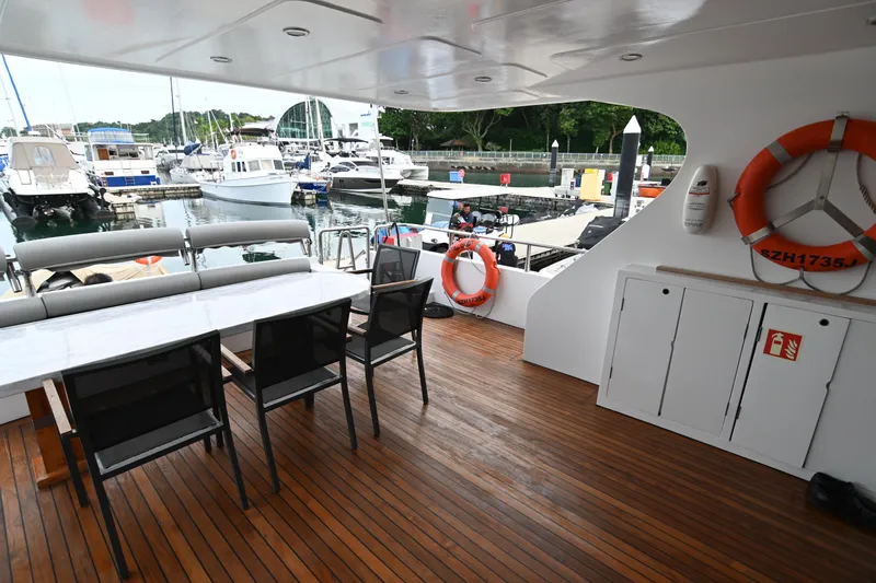  Yacht Photos Pics Luxurious yacht deck with seating, wooden flooring, and marina view; Accelera 82, 2014 model.