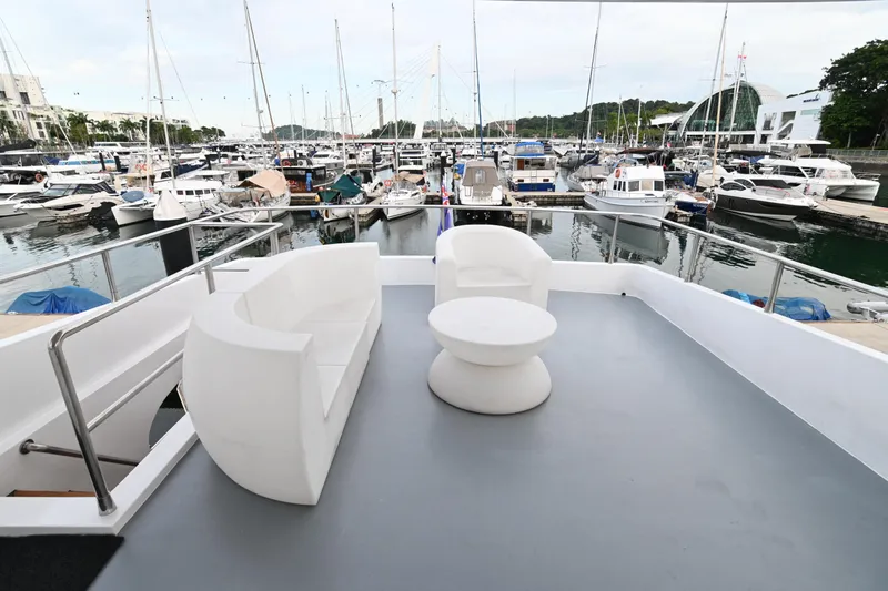  Yacht Photos Pics Luxury yacht deck with modern white furniture, overlooking a marina filled with boats.