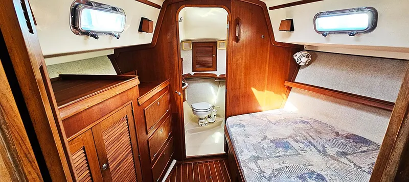 Kewaydin Yacht Photos Pics 1997 Island Packet 40 yacht interior with wooden cabinetry, bed, and compact bathroom.