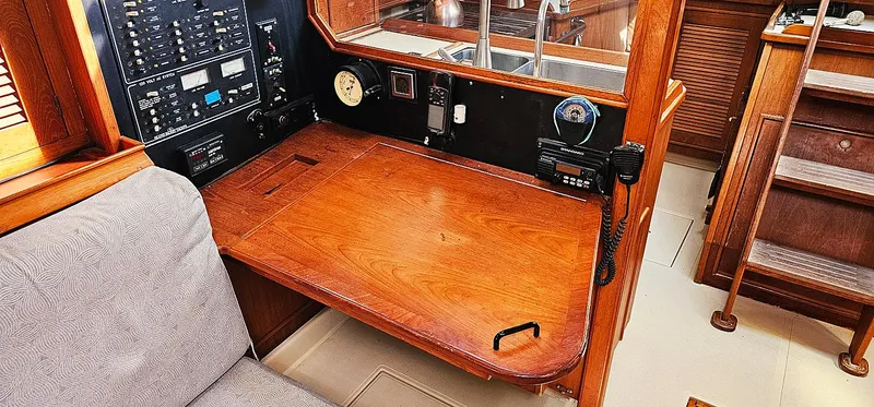 Kewaydin Yacht Photos Pics Navigation station on a 1997 Island Packet 40 sailboat with wooden desk and control panel.