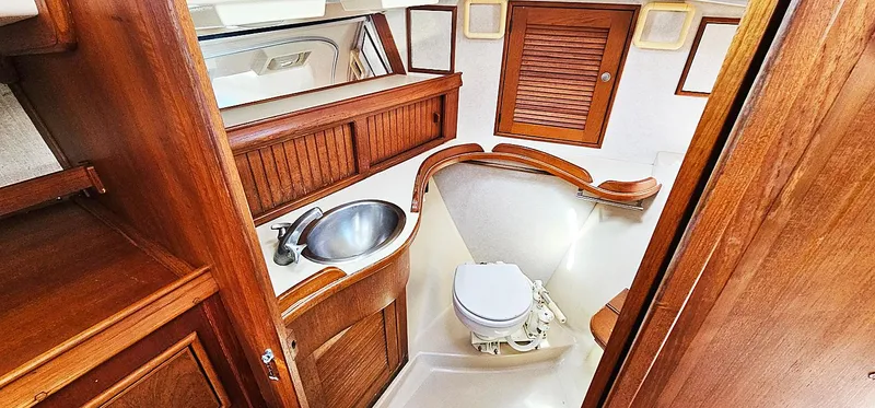 Kewaydin Yacht Photos Pics 1997 Island Packet 40 yacht bathroom with wooden cabinetry and stainless steel sink.