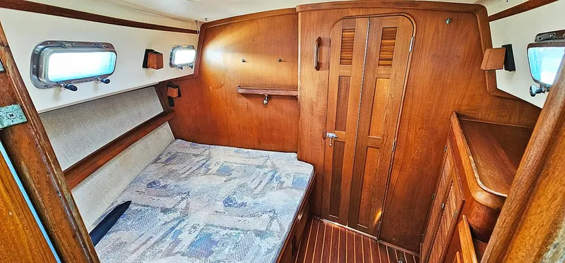 Kewaydin Yacht Photos Pics Cozy cabin interior of 1997 Island Packet 40 sailboat with wooden finish and bed.