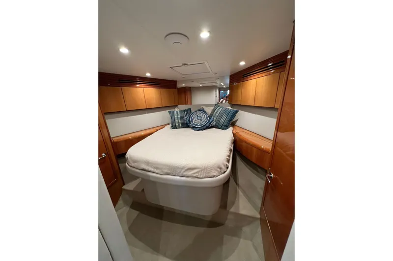  Yacht Photos Pics Luxurious cabin interior of 2006 Hatteras 54 Convertible yacht with cozy bed and wooden cabinetry.