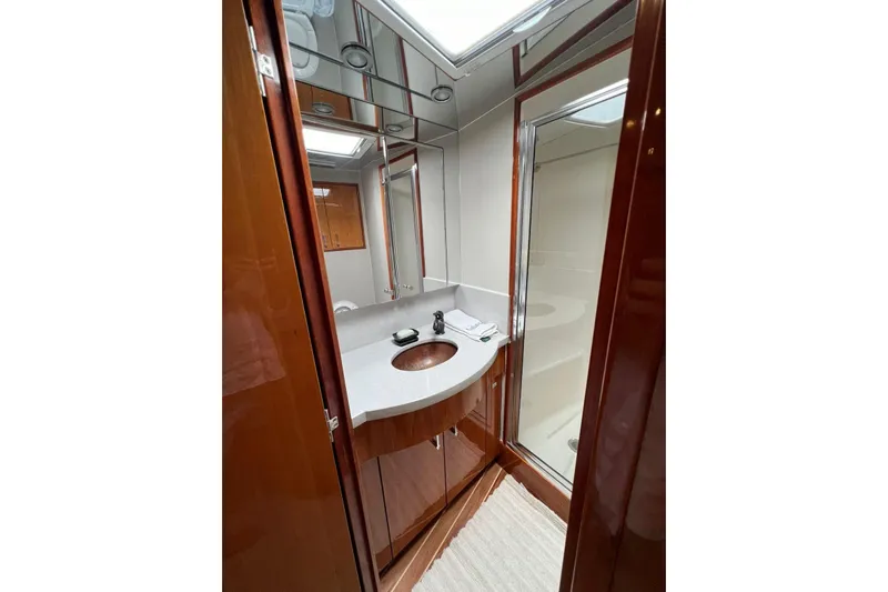  Yacht Photos Pics Luxurious bathroom in 2006 Hatteras 54 Convertible yacht with modern fixtures and wood accents.