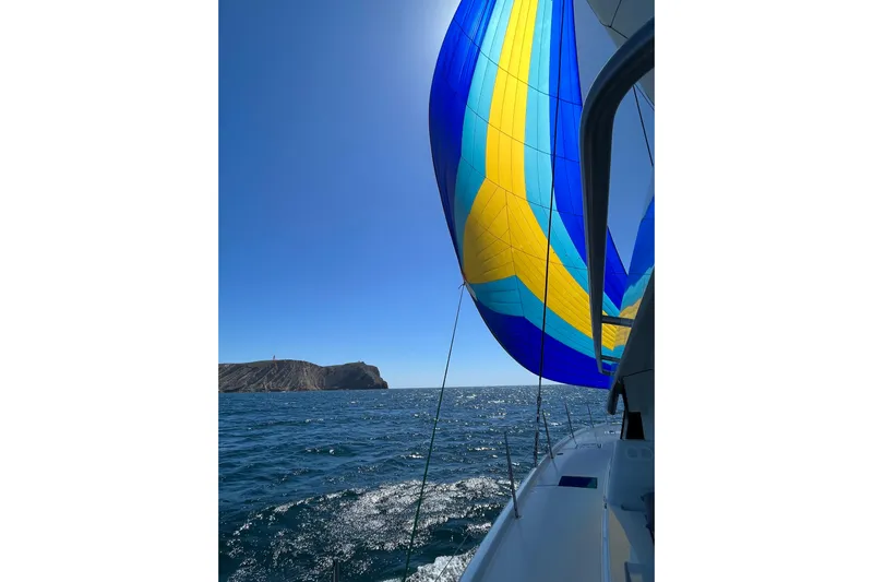 Free To Be Yacht Photos Pics 2022 Fountaine Pajot Elba 45 Catamaran sailing with vibrant blue and yellow spinnaker.