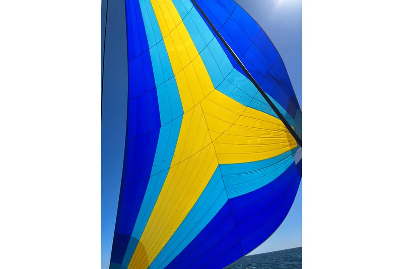 Free To Be Yacht Photos Pics Colorful sail of 2022 Fountaine Pajot Elba 45 Catamaran against clear blue sky.