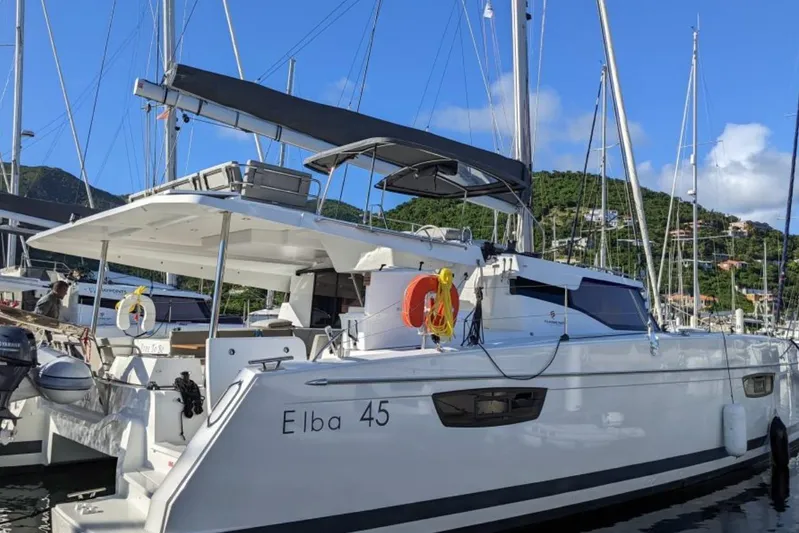 Free To Be Yacht Photos Pics 2022 Fountaine Pajot Elba 45 Catamaran docked in a scenic marina.
