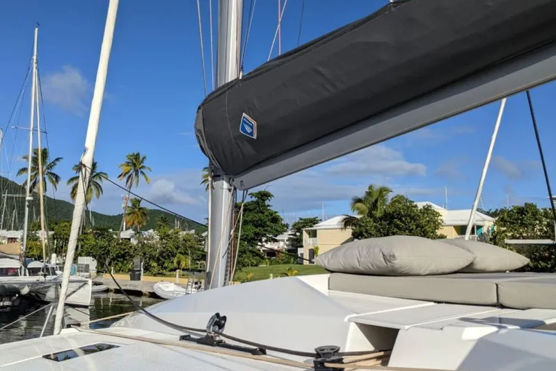 Free To Be Yacht Photos Pics 2022 Fountaine Pajot Elba 45 Catamaran docked, with palm trees and blue sky background.