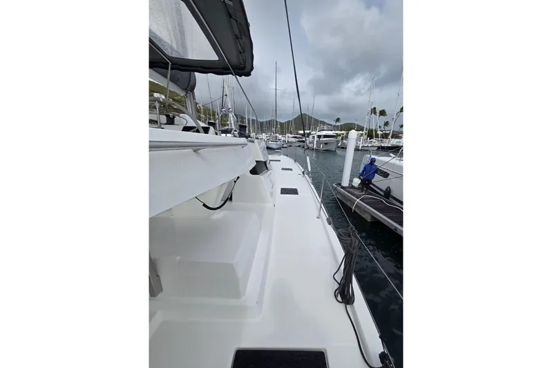 Free To Be Yacht Photos Pics 2022 Fountaine Pajot Elba 45 Catamaran docked in a marina under cloudy skies.