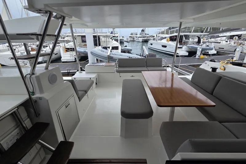 Free To Be Yacht Photos Pics 2022 Fountaine Pajot Elba 45 Catamaran interior with seating and table, docked at marina.