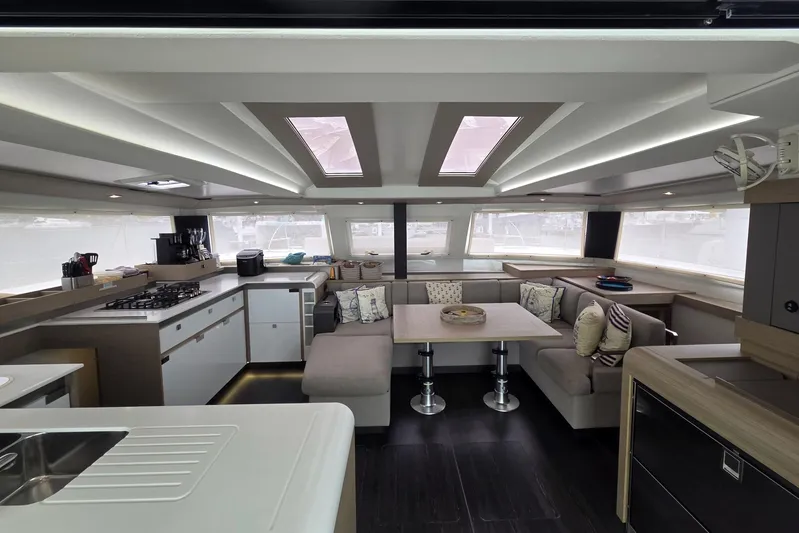 Free To Be Yacht Photos Pics Luxurious interior of 2022 Fountaine Pajot Elba 45 Catamaran with modern kitchen and seating area.