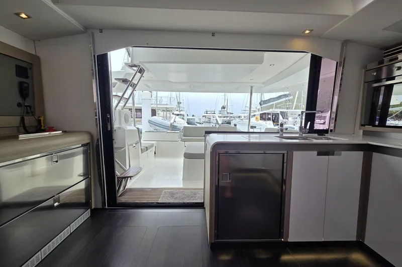 Free To Be Yacht Photos Pics Interior view of 2022 Fountaine Pajot Elba 45 Catamaran, showcasing modern kitchen and open deck.