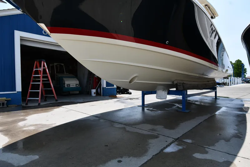  Yacht Photos Pics 2024 Chris-Craft Catalina 30 boat on stands, near blue garage, sunny day.