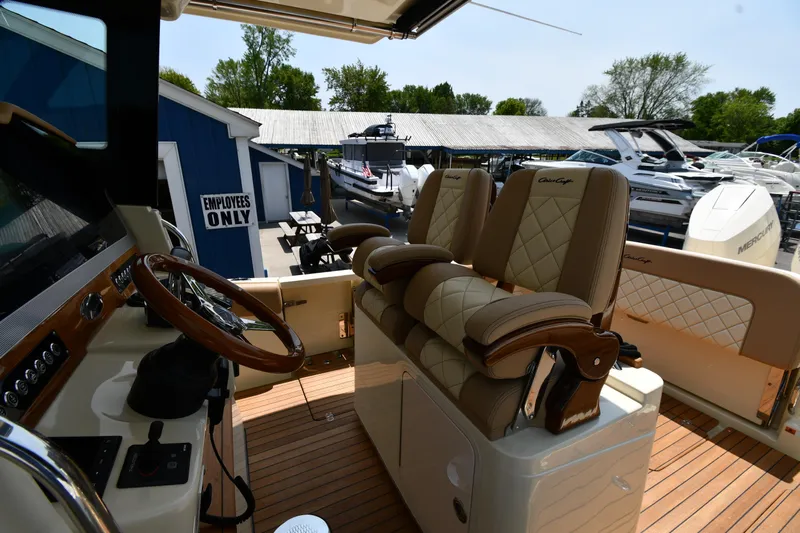  Yacht Photos Pics 2024 Chris-Craft Catalina 30 interior with luxurious seating and helm, docked at a marina.