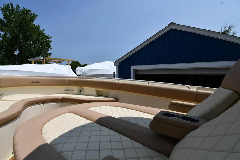  Yacht Photos Pics 2024 Chris-Craft Catalina 30 boat interior with beige seating, near a blue building.