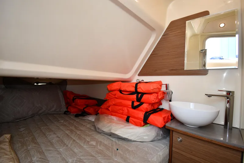  Yacht Photos Pics 2024 Chris-Craft Catalina 30 cabin with bed, life jackets, and modern sink.