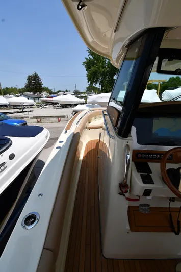  Yacht Photos Pics 2024 Chris-Craft Catalina 30 boat with sleek design and wooden deck, docked outdoors.