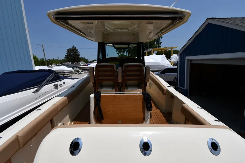  Yacht Photos Pics 2024 Chris-Craft Catalina 30 boat, rear view, docked near blue building.