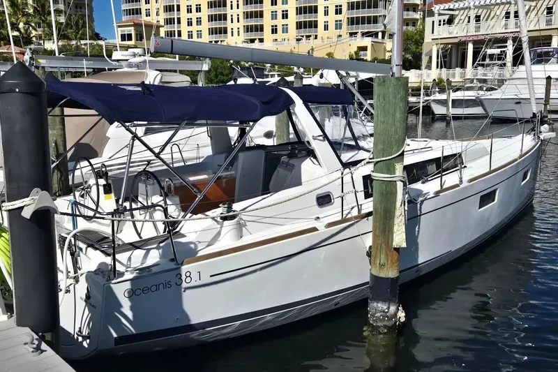 Bluebird Yacht Photos Pics 2023 Beneteau Oceanis 38.1 yacht docked at marina, featuring sleek design and blue canopy.