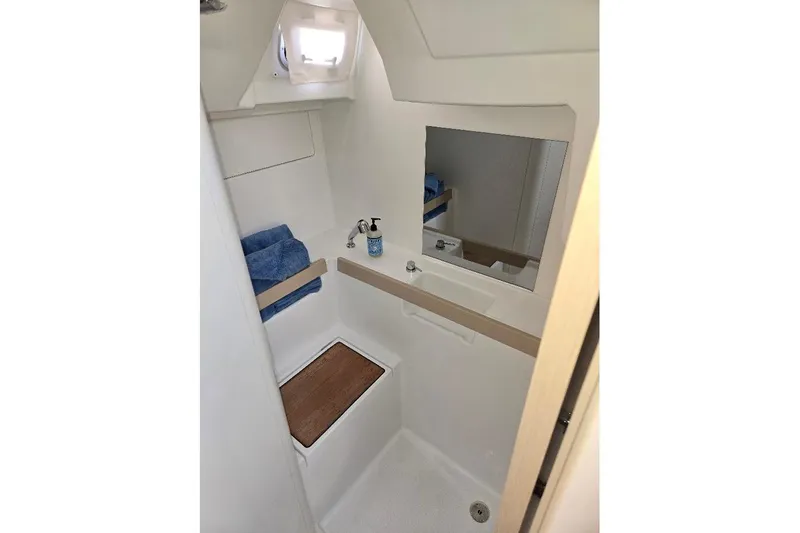 Bluebird Yacht Photos Pics 2023 Beneteau Oceanis 38.1 bathroom with mirror, sink, and wooden accents.