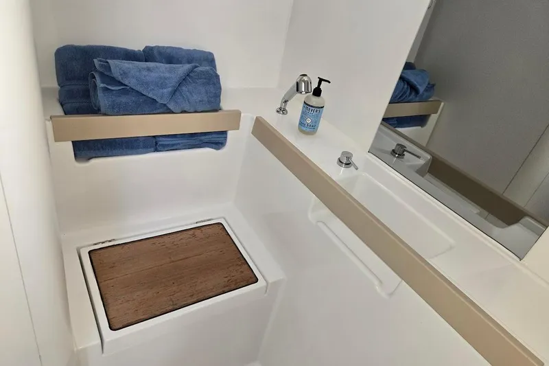 Bluebird Yacht Photos Pics Bathroom interior of 2023 Beneteau Oceanis 38.1 yacht with towels and soap.