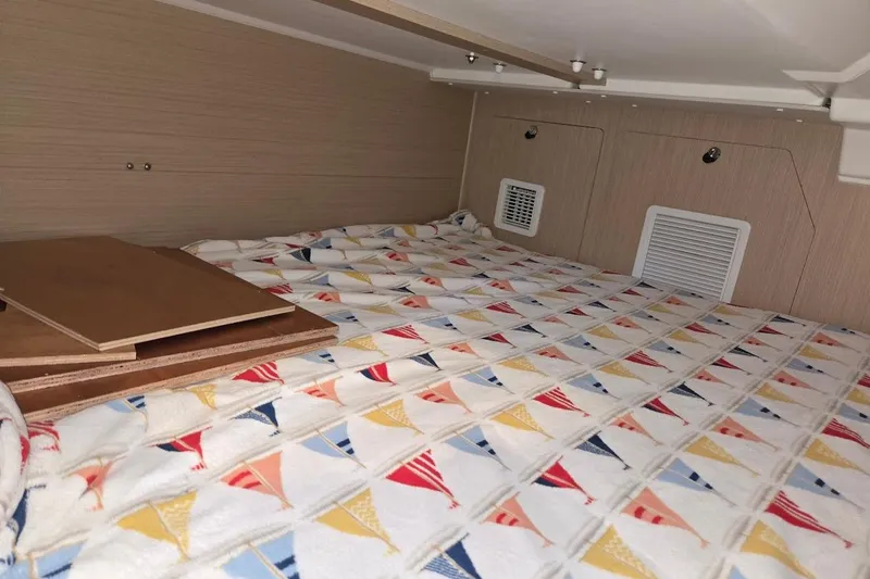Bluebird Yacht Photos Pics Cozy cabin interior of 2023 Beneteau Oceanis 38.1 with colorful patterned bedding.