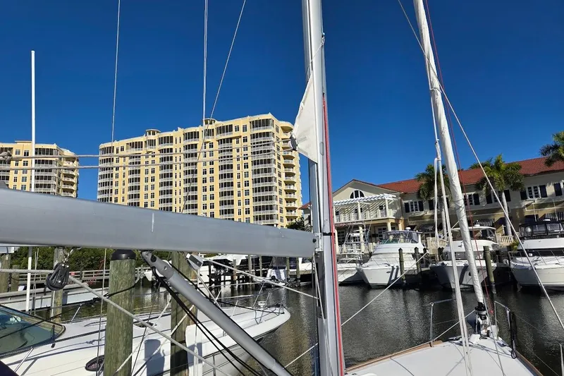 Bluebird Yacht Photos Pics 2023 Beneteau Oceanis 38.1 sailboat docked at marina with waterfront buildings.