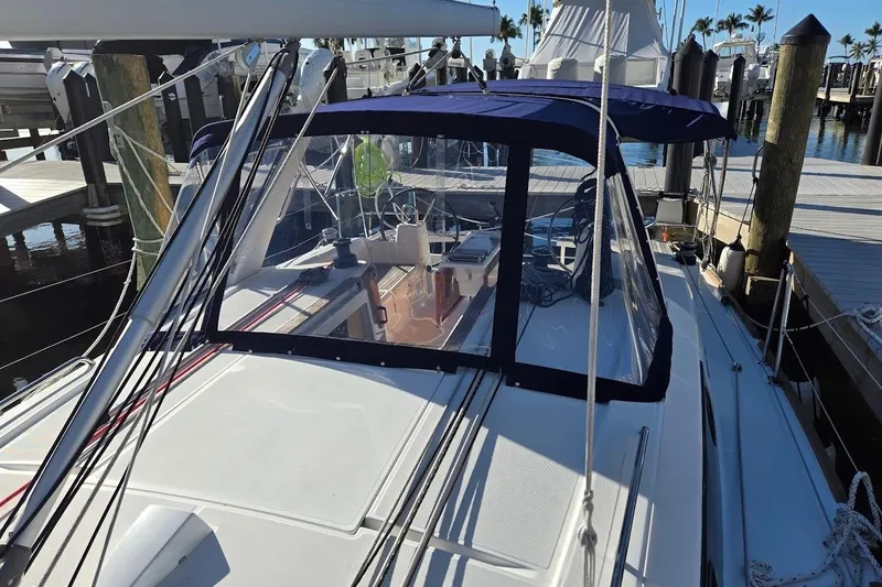 Bluebird Yacht Photos Pics 2023 Beneteau Oceanis 38.1 sailboat docked at marina, featuring blue canopy and sleek design.