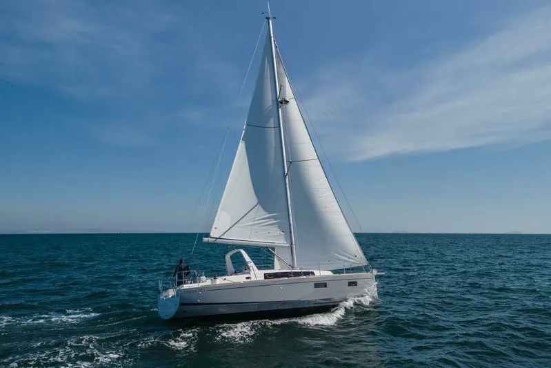 Bluebird Yacht Photos Pics 2023 Beneteau Oceanis 38.1 sailing on open sea under clear blue sky.