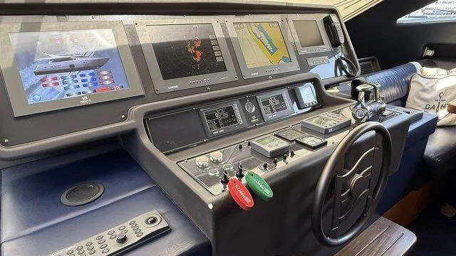 Happy Landing Yacht Photos Pics Control panel of a 2007 Ferretti Yachts 731 with navigation screens and steering wheel.