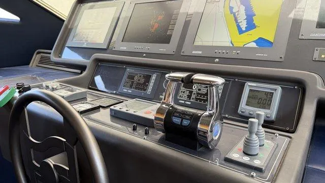 Happy Landing Yacht Photos Pics Control panel of a 2007 Ferretti Yachts 731 with navigation screens and steering wheel.