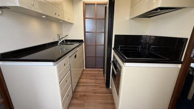 Happy Landing Yacht Photos Pics Modern kitchen interior on 2007 Ferretti Yachts 731, featuring sleek cabinetry and black countertops.