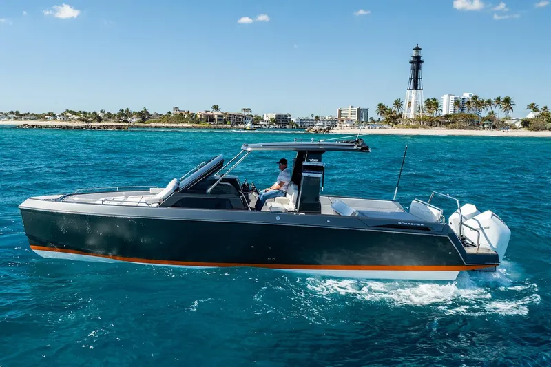  Yacht Photos Pics 2024 Schaefer V33 boat cruising near a lighthouse on clear blue waters.