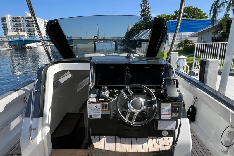  Yacht Photos Pics 2024 Schaefer V33 boat helm with modern controls, docked by a scenic waterfront.