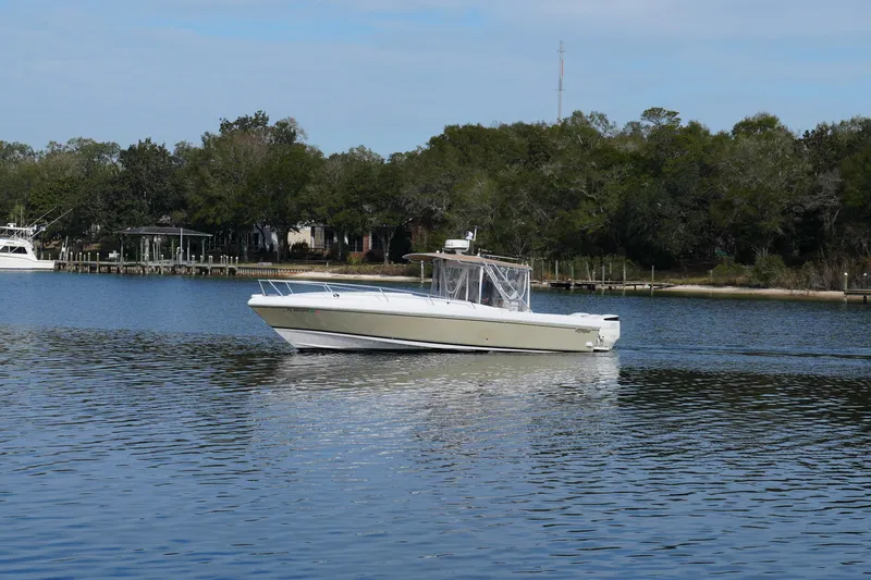  Yacht Photos Pics 1999 Intrepid 366 boat cruising on a calm lake with a forested shoreline.