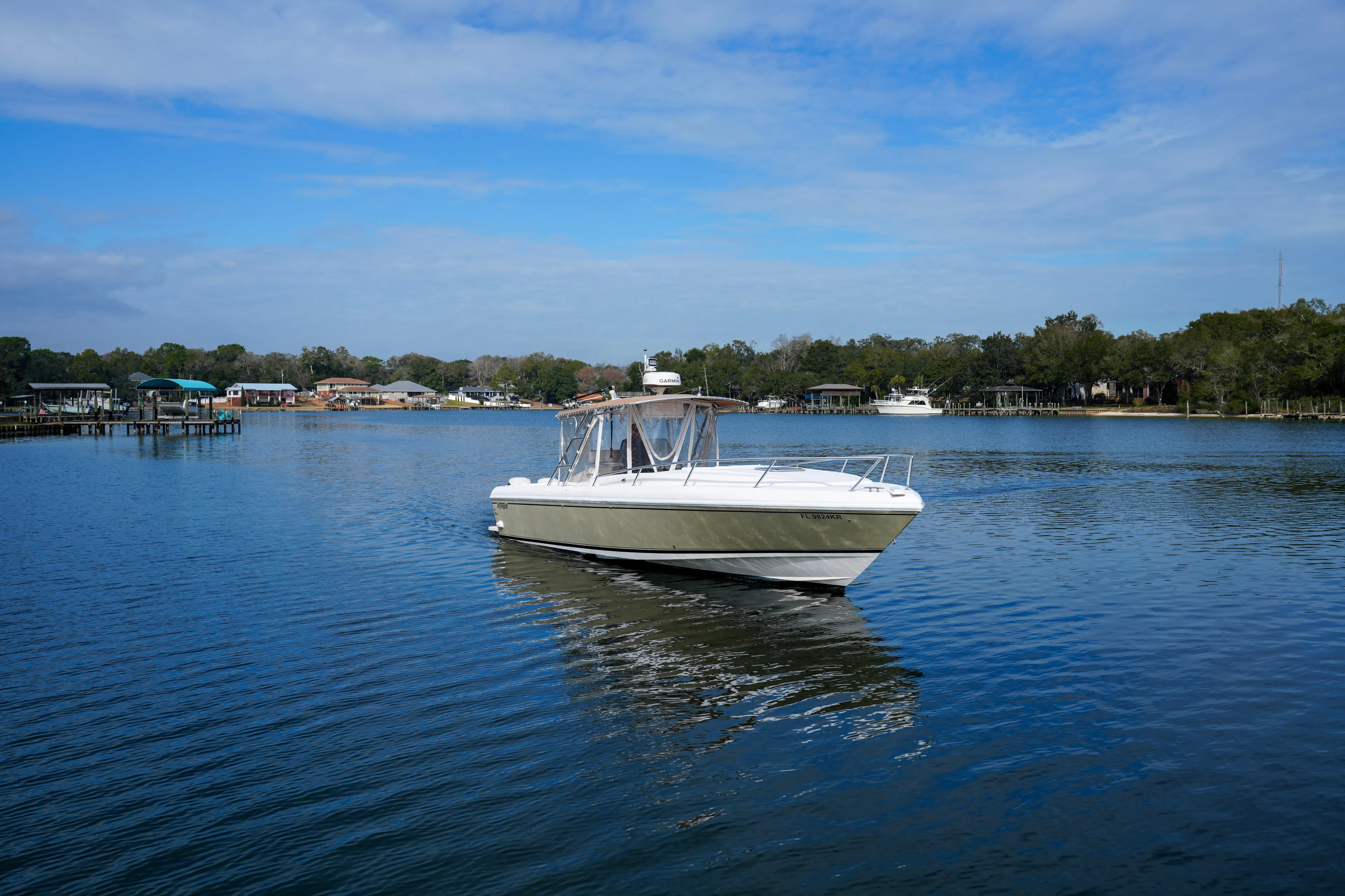  Yacht Photos Pics 1999 Intrepid 366 boat on calm lake with scenic shoreline background.