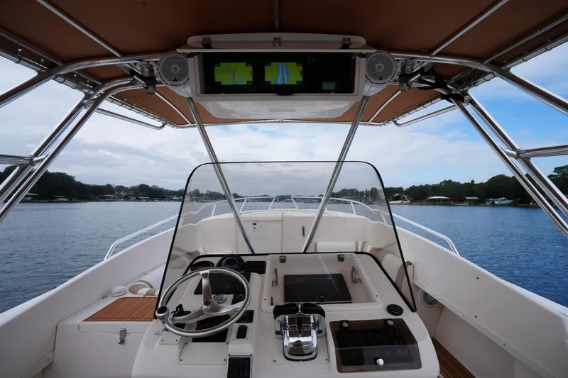  Yacht Photos Pics 1999 Intrepid 366 boat cockpit with steering wheel and navigation screens on a calm lake.