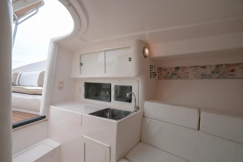  Yacht Photos Pics Interior of 1999 Intrepid 366 boat with sink, seating, and storage cabinets.