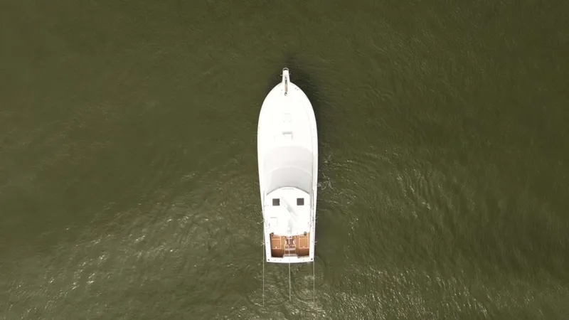 Bill Slayer Yacht Photos Pics Aerial view of 2002 Cabo 47 Flybridge Sportfisher on calm water.