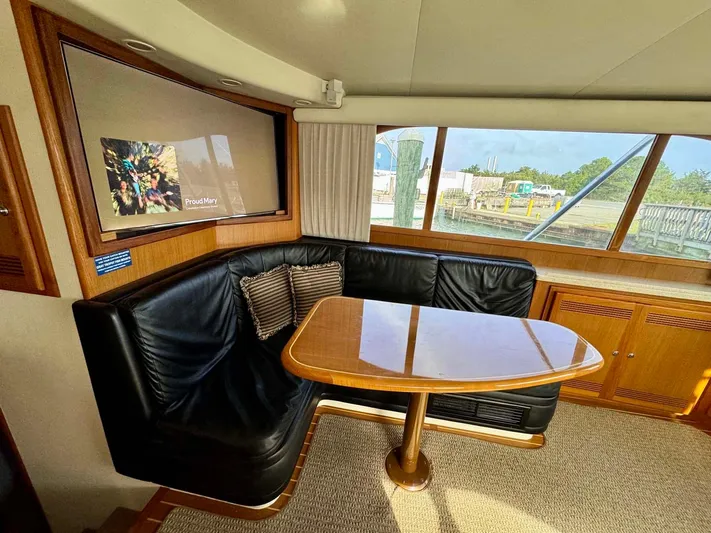 Bill Slayer Yacht Photos Pics Interior of 2002 Cabo 47 Flybridge Sportfisher with leather seating and wooden table.
